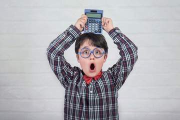 Happy student showing calculator over his head