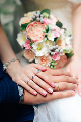 Obraz na płótnie Canvas beautiful wedding bouquet with gold rings, bridal accessories