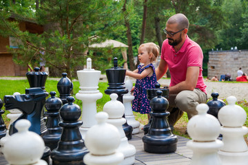 girl and her father with giant chess