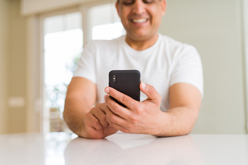 Close up of middle age man hands using smartphone at home