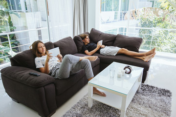 Teenagers using tablet pc on couch