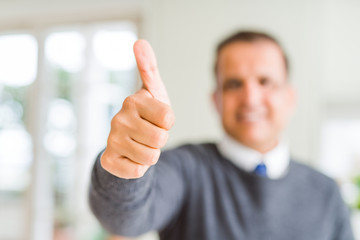 Middle age man doing postive gesture with thumbs up smiling to the camera