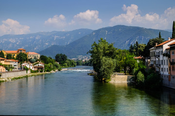Fototapeta na wymiar Brenta River and the Alpi Mountains. Bassano del Grappa, Vicenza, Veneto, Italy. 9th August 2019