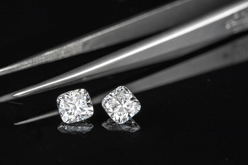 cushion diamonds with tweezer on black reflection background