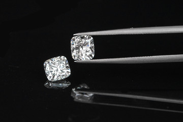 cushion diamonds with tweezer on black reflection background