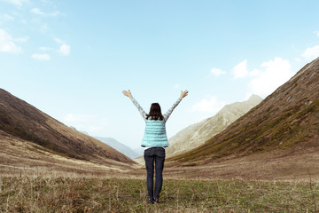 woman in a mountain valley arms raised in the sky travel lifestyle concept of success adventure adventure active holidays outdoors happiness freedom emotions - Stock Image