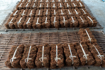 Farmer is preparing blocks of dried tobacco which is ready to be sold.