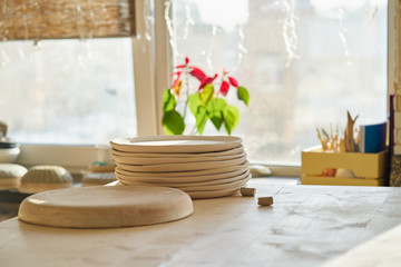 Ceramic studio, manufacturing, workpiece. Beautiful background with ceramic pieces of ware against the window, sun light