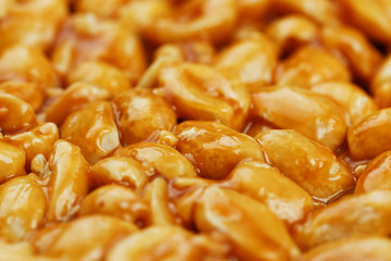 Kozinaki from golden, roasted peanuts beans as a background, texture. Macro shooting, close-up. Place for text