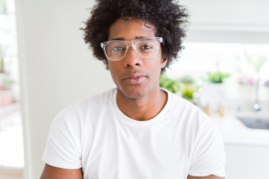African American man wearing glasses Relaxed with serious expression on face. Simple and natural with crossed arms