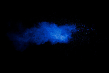 Abstract art blue powder on black background.