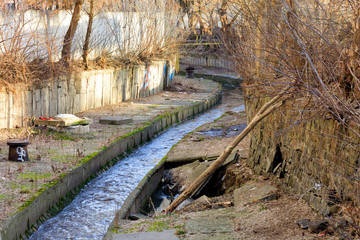 The dirty river Lybid flows along a channel enclosed in a concrete chute.