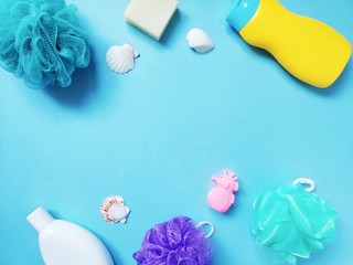 Flat lay spa cosmetics and toiletries set. Shampoo, shower gel, soap bar, colorful sponges and rubber toy. Mockup with free space for text
