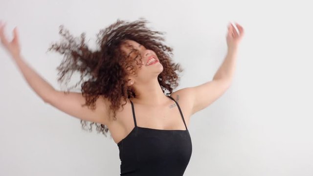 fun mixed race model with freckles shake her hair in slow motion from 60 fps and then lift up her curly hair