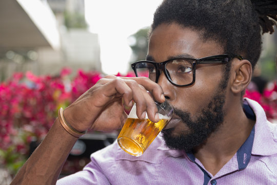 Black man drinking beer.