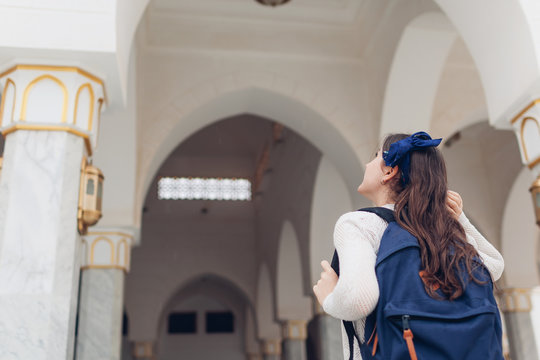 Young woman traveler going sightseeing in Egypt. Girl walking on excursion looking at Al Salam mosque