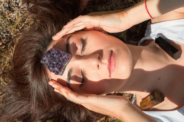 Woman put amethyst stone on her forehead