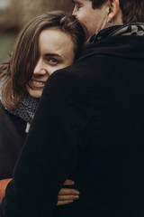 stylish man and woman hugging. romantic calm atmospheric moment. couple embracing gently in autumn park, showing true feelings. family togetherness concept