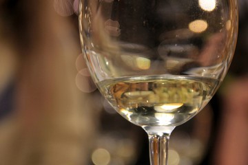 White wine is poured on the bottom of the glass and around the bokeh