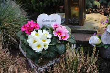 Grabschmuck mit Blumen und Herz im Frühling