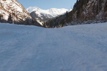 snowy road in the mountains of Ili Alatau leading to the lake