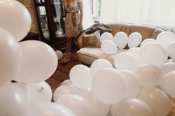 Bunch of white air balloons in luxury hotel room, morning before wedding preparation decorations white balloons