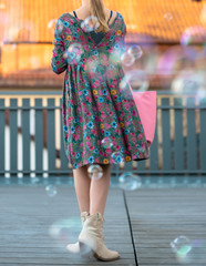 girl in a flower dress is walking, soap bubbles are flying behind her