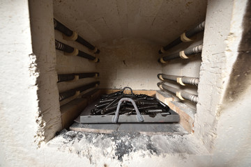 The metal parts of the actuator from the valve are installed in an electric furnace for hardening.