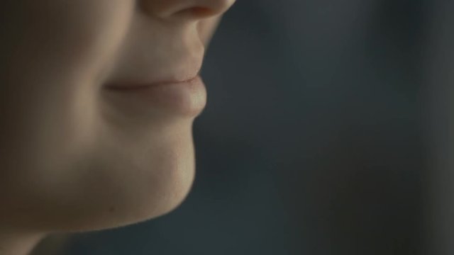 lips young woman talks at home with a friend at the window, part of the face is a girl smiling, concept of health and friendship