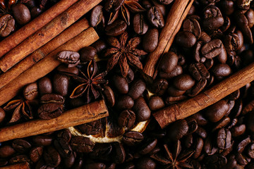 Cinnamon sticks, star anise, coffee beans and dried orange on the kitchen table. Fragrant spices for coffee drink, close-up.