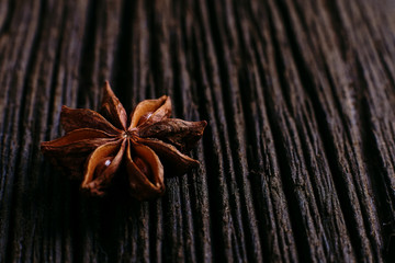 Star anise on a wooden background, close-up of a spice.