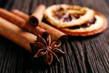 Cinnamon sticks, star anise and dried orange on the kitchen table. Fragrant spices, closeup.