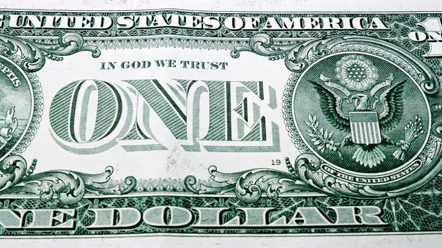Sliding video of a one US dollar bill note, showing ONE text and image of the pyramid and the eagle. Macro shot. Close up.
