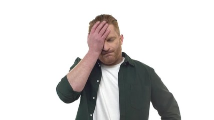 Slow motion annoyed pissed attractive redhead bearded 30s guy slapping forehead palm facepalm gesture, expressing regret disappointment or dismay, standing displeased upset fed up white background - Powered by Adobe