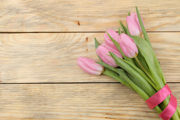 Beautiful bouquet of flowers of pink tulips on a natural wooden background. Place for text. top view. Spring. holidays.