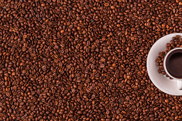Cup of coffee on a background of coffee beans