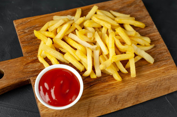 French fries with ketchup on wooden background