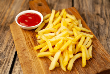 French fries with ketchup on wooden background