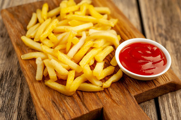 French fries with ketchup on wooden background