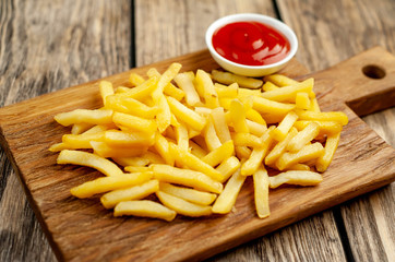 French fries with ketchup on wooden background