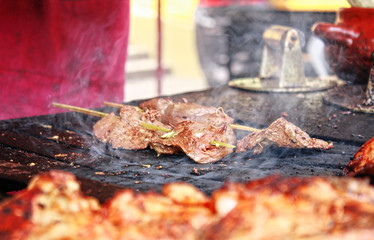 Traditional Peruvian food 'Anticuchos' (grilled skewered beef heart meat) cooked on barbecue grill
