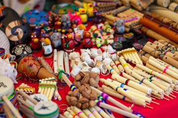 Fototapeta na wymiar Colorful Peruvian artisanal crafts and Andean musical instruments for sale at street market in Cusco