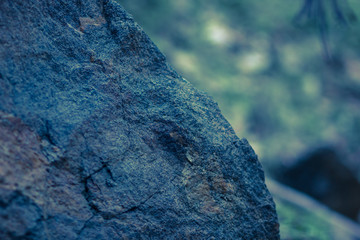 Granite rocks in blue-green tinting. Granite close up. Texture of the stone with blue color. Background from natural material with cool shades