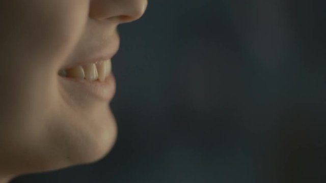 lips young woman talks at home with a friend at the window, part of the face is a girl smiling, concept of health and friendship