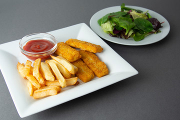 Fish and chips with french fries - unhealthy food, grey backgrpound.