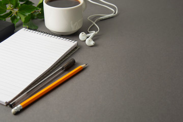 Creative flat lay of workspace desk. Top view office desk with notebooks and coffee cup on grey background. Top view with copy space. Minimalistic work space.