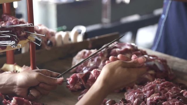 the process of making delicious sate or satay using metal skewers