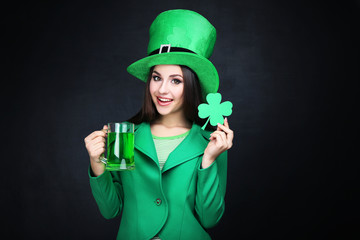 St. Patrick's Day. Beautiful woman wearing green hat with beer and paper clover