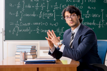 Young male math teacher in classroom 