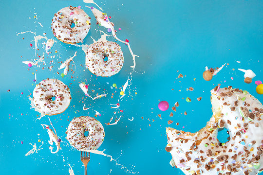 Floating in the air donuts on a blue background. Sweets, pastries.